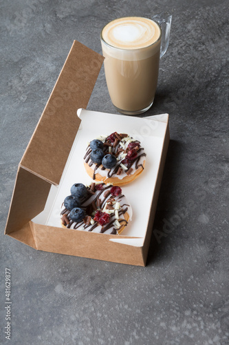Box of fresh donuts to go on a black table