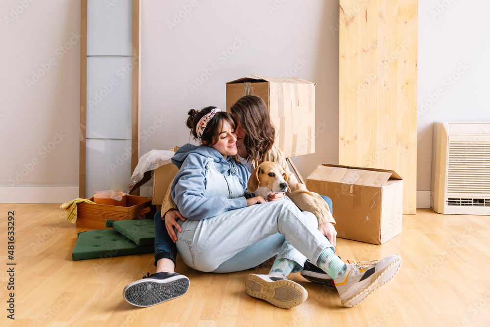 Girlfriends with dogs hugging near carton boxes Girlfriends with dogs hugging near carton boxes