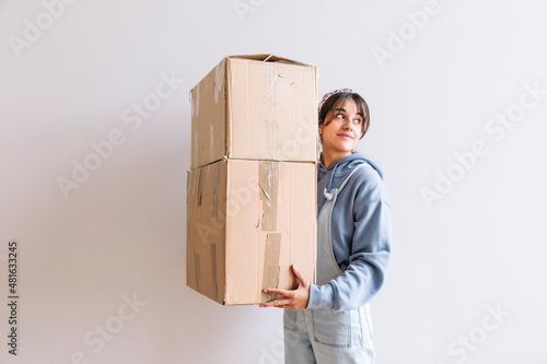Positive woman carrying carton boxes