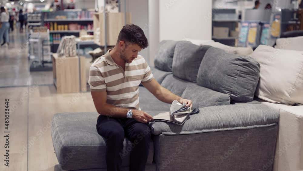 Man choosing sofa upholstery in shopping center