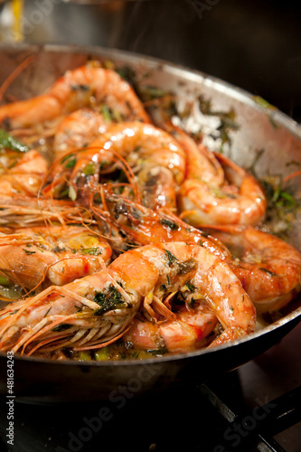 Shrimp also known as prawn in a frying pan with cilantro.