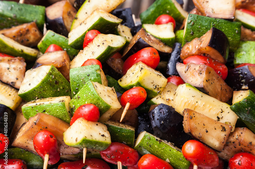 Vegetable skewer close-up. Fried on wooden sticks zucchini, cherry tomatoes, eggplant and bell peppers.