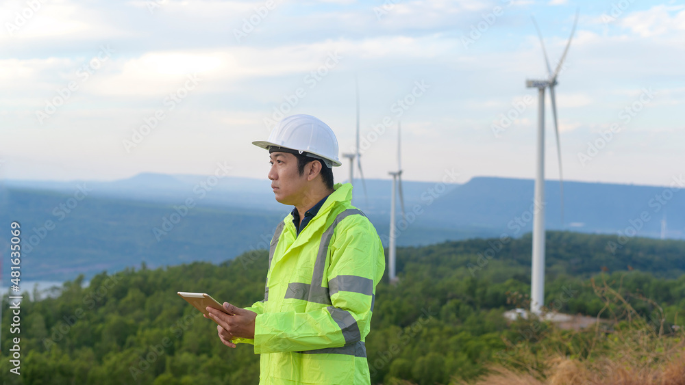 a man engineer is wearing a protective helmet on her head, using tablet Analytics engineering data... a man engineer is wearing a protective helmet on her head, using tablet Analytics engineering data...