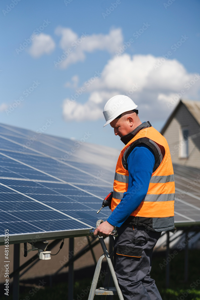 Solar panel assembler stands on a ladder Solar panel assembler stands on a ladder