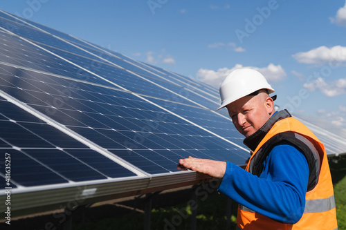 Solar plant worker inspecting photovoltaic panels for damage