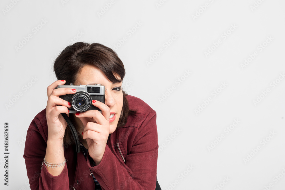 Young beautiful woman taking a photo with a retro camera Young beautiful woman taking a photo with a retro camera