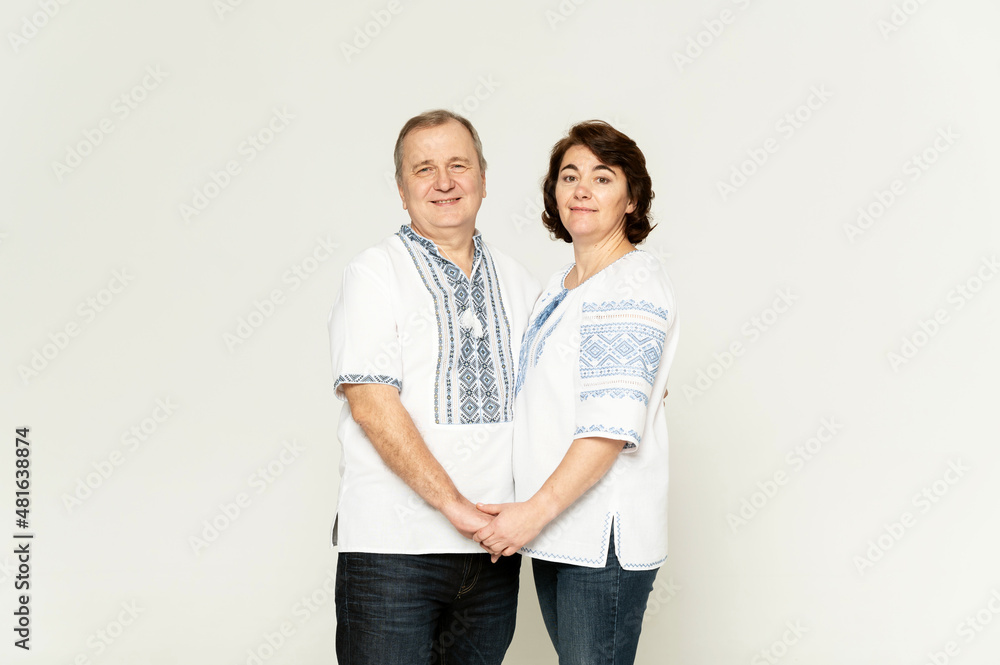 middle-aged couple in Ukrainian costumes on a white background. a man and a woman in embroidered shirts. middle-aged couple in Ukrainian costumes on a white background. a man and a woman in embroidered shirts.