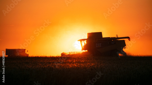 Combine harvester working at sunset