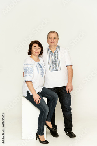 couple in national clothes on a white background. husband and wife in embroidered shirts. people of retirement age.Cotton clothes with national ornaments