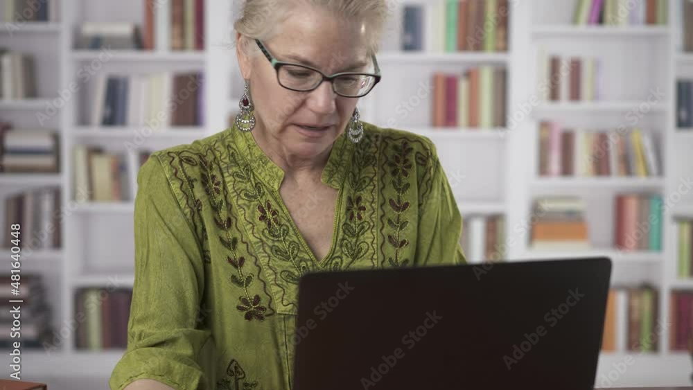 Camera pans down from woman smiling face to holding credit card and typing on laptop keyboard tas she makes online purchase. Camera pans down from woman smiling face to holding credit card and typing on laptop keyboard tas she makes online purchase.