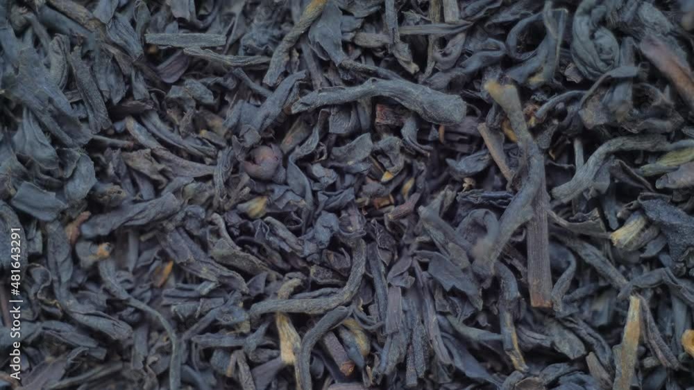 Top view: heap of dried black tea on slow rotating surface - macro, close up view: nobody, no people Top view: heap of dried black tea on slow rotating surface - macro, close up view: nobody, no people