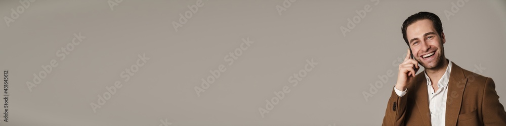 Unshaven brunette man smiling and talking on cellphone Unshaven brunette man smiling and talking on cellphone