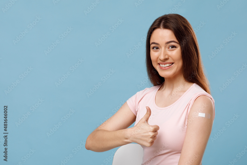 Happy woman showing arm with adhesive plaster and smiling Happy woman showing arm with adhesive plaster and smiling