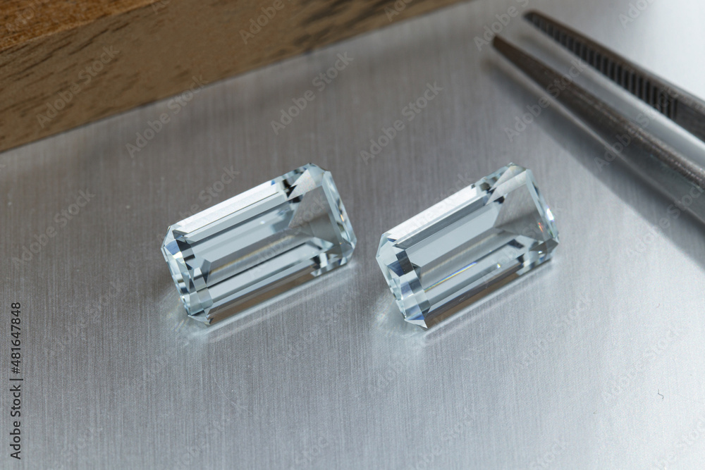 macro mineral faceted stone aquamarine with tweezers on a gray background macro mineral faceted stone aquamarine with tweezers on a gray background