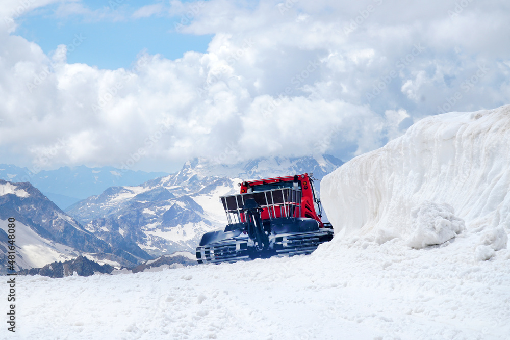 Snowplow at a snowy ski resort during sunset Snowplow at a snowy ski resort during sunset