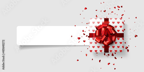 White gift box with hearts pattern and beautiful red bow. Red foil confetti. Valentine's day.