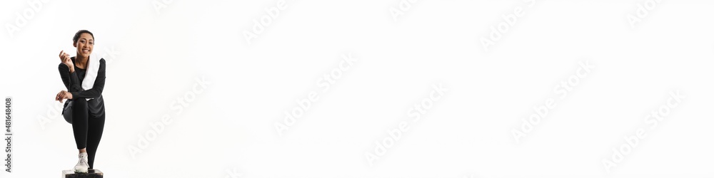 Happy young african sportswoman resting with towel Happy young african sportswoman resting with towel