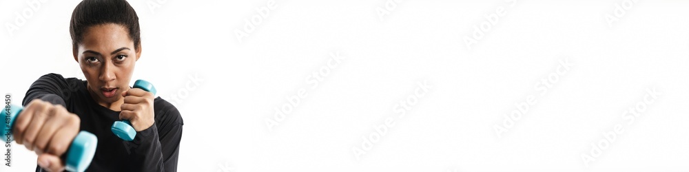 Focused african american woman working out with dumbbells Focused african american woman working out with dumbbells