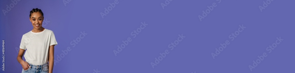Young black woman in t-shirt smiling and looking at camera Young black woman in t-shirt smiling and looking at camera