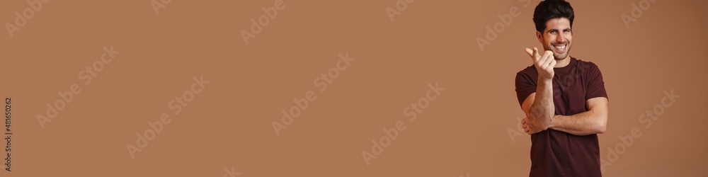 Joyful masculine man smiling and pointing finger at camera Joyful masculine man smiling and pointing finger at camera
