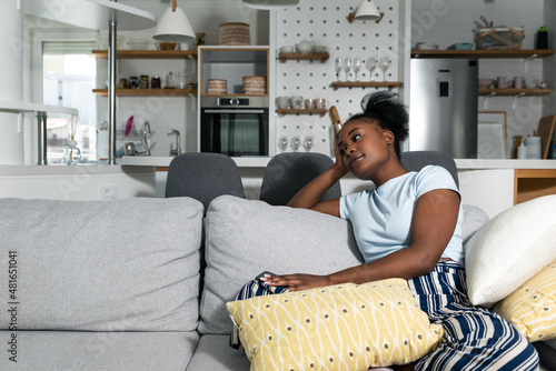 Fotografie Young scared sad and depressed woman suffering form agoraphobia depression and anxiety sitting inside her home having fear to go outside