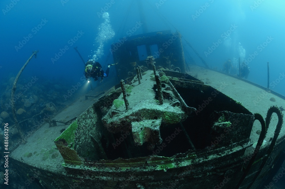 Scuba divers explore ship wreck Hermes, Bermuda Island, Atlantic Scuba divers explore ship wreck Hermes, Bermuda Island, Atlantic