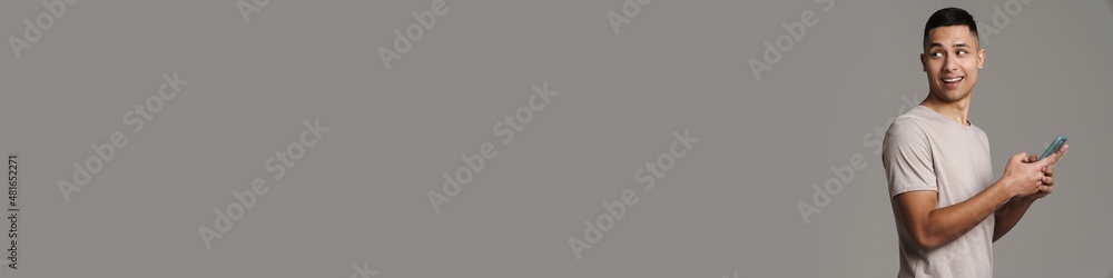 Happy handsome guy using mobile phone and smiling