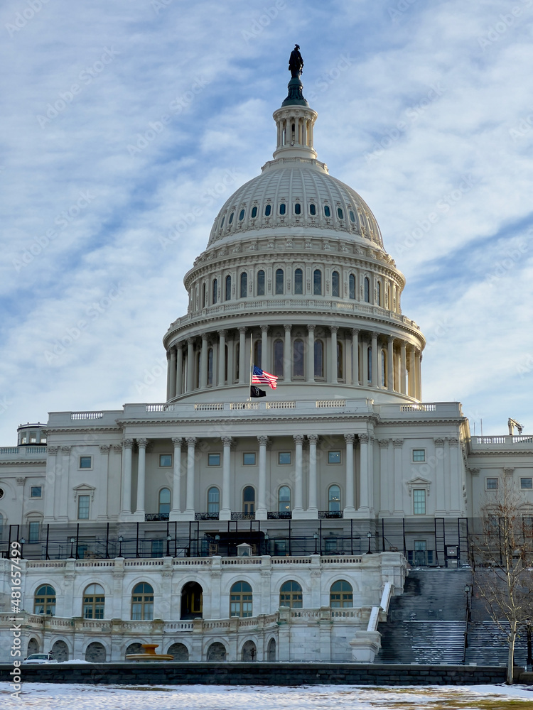 Fototapeta premium US Congress on a winter morning.Parliamentary dome. High fences are installed on the balconies where people have invaded.The national flag in the center of the parliament is a half-mast.