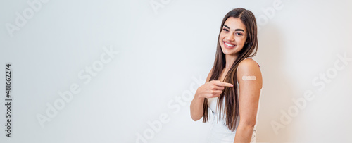 Foto Young girl woman showing pointing with finger to bandage on her arm shoulder cheerful happy and smiling done with vaccination