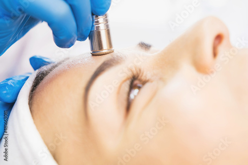 Obraz na płótnie Close up photo of a woman undergoes procedure microdermabrasion against acne and blackheads in a beauty salon. w salonie
