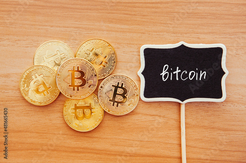 Golden Bitcoin coins and lettering on chalkboard, crypto currency concept and digital money	