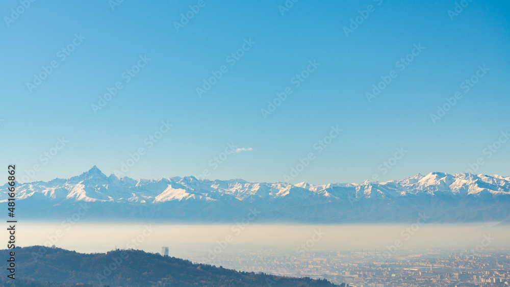 Aerial view of the city of Torino (Turin), Piedmont, Italy, from the hill where the Basilica di Superga (meaning: Superga's Cathedral), lies. Blue sky on the background withcopy-space.