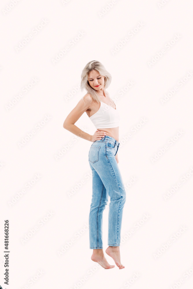 Portrait of a beautiful blonde with long hair posing in the studio on a white wall. Portrait of a beautiful blonde with long hair posing in the studio on a white wall.