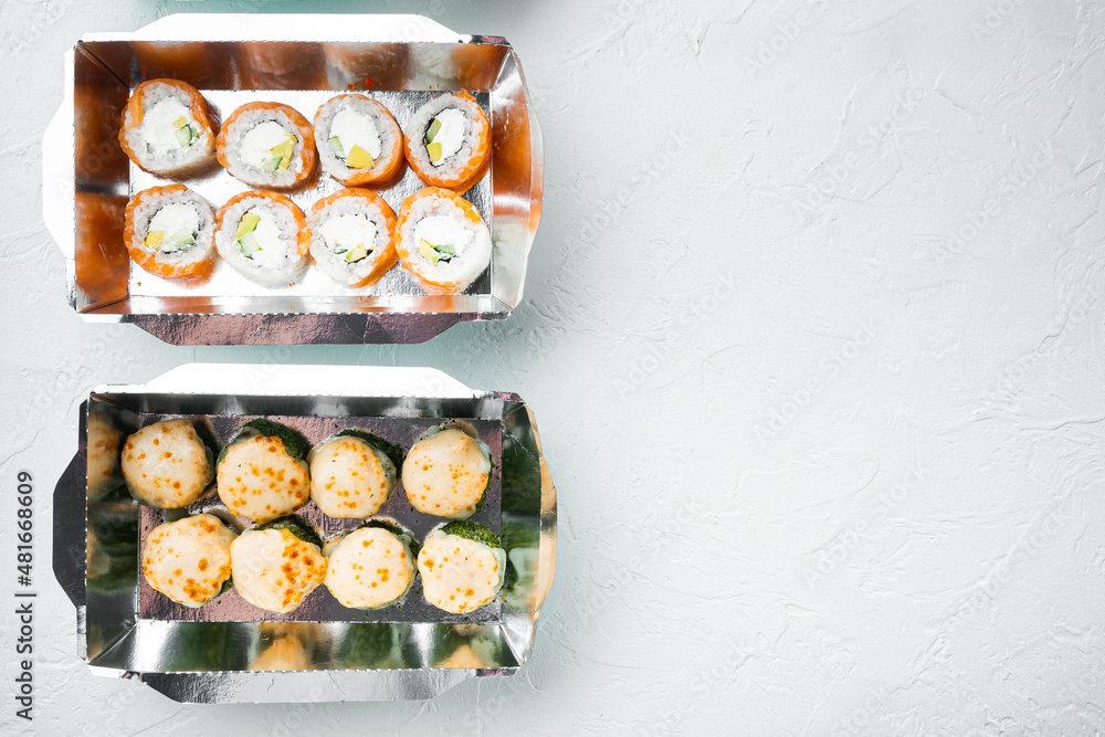 Japanese food concept. Catering, various kinds of sushi philadelphia rolls and baked prawn rolls, on white stone  background, top view flat lay , with copyspace  and space for text