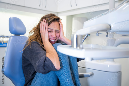 Young female patient screaming at the dental clinic
