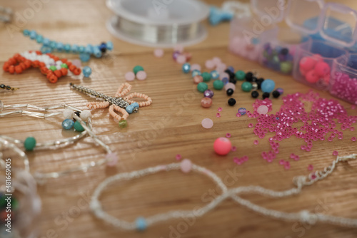 Beautiful handmade beaded jewelry and supplies on wooden table