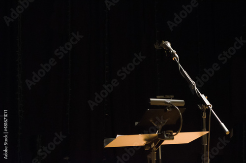 Music stand with microphone on a stage with a black background photo