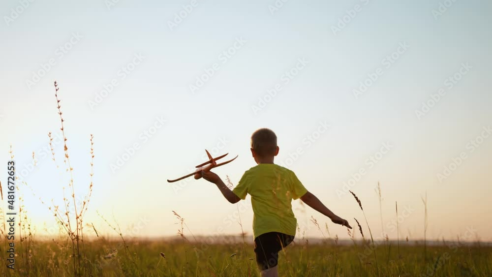 child runs with silhouette toy airplane in park field. childhood kid dream happy family concept. boy running with toy airplane in park at sunset. boy kid play dream of sunlight becoming a pilot child runs with silhouette toy airplane in park field. childhood kid dream happy family concept. boy running with toy airplane in park at sunset. boy kid play dream of sunlight becoming a pilot