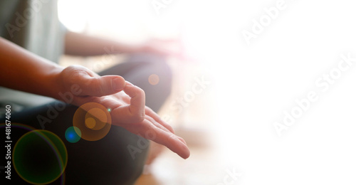 Close-up of woman's hand during meditation sitting on windowsill. Mental healthcare concept.