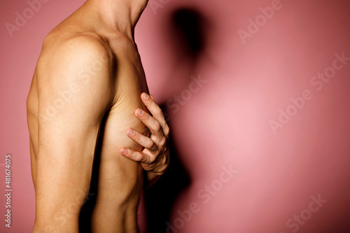 Close up man breast hold hand on his heart over pink background