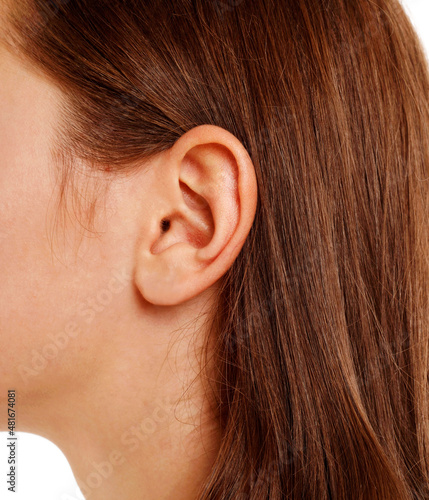 Close up human woman's ear over white background