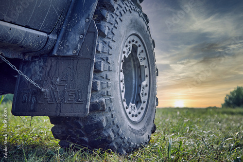 An off-road car splattered with mud against a beautiful sky. Car tire and mudguard 4x4. Off-road tire