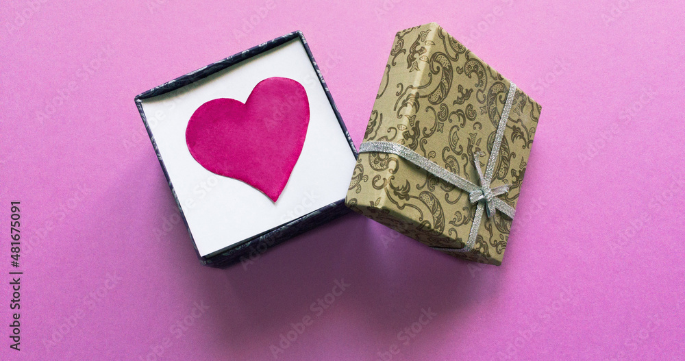 Valentine's Day holiday gift. Red heart inside the gift box on a pink background Valentine's Day holiday gift. Red heart inside the gift box on a pink background