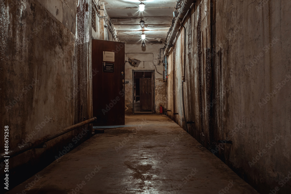 A beautiful corridor with shabby walls in an abandoned underground bunker. Old underground building. Shabby walls. Low light. A beautiful corridor with shabby walls in an abandoned underground bunker. Old underground building. Shabby walls. Low light.