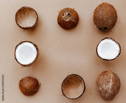Fresh coconuts with cracked coconut fruit piece on brown background.Whole coconut, shell from coconut. Tropical fruit Food photo.