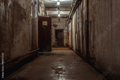 A beautiful corridor with shabby walls in an abandoned underground bunker. Old underground building. Shabby walls. Low light.