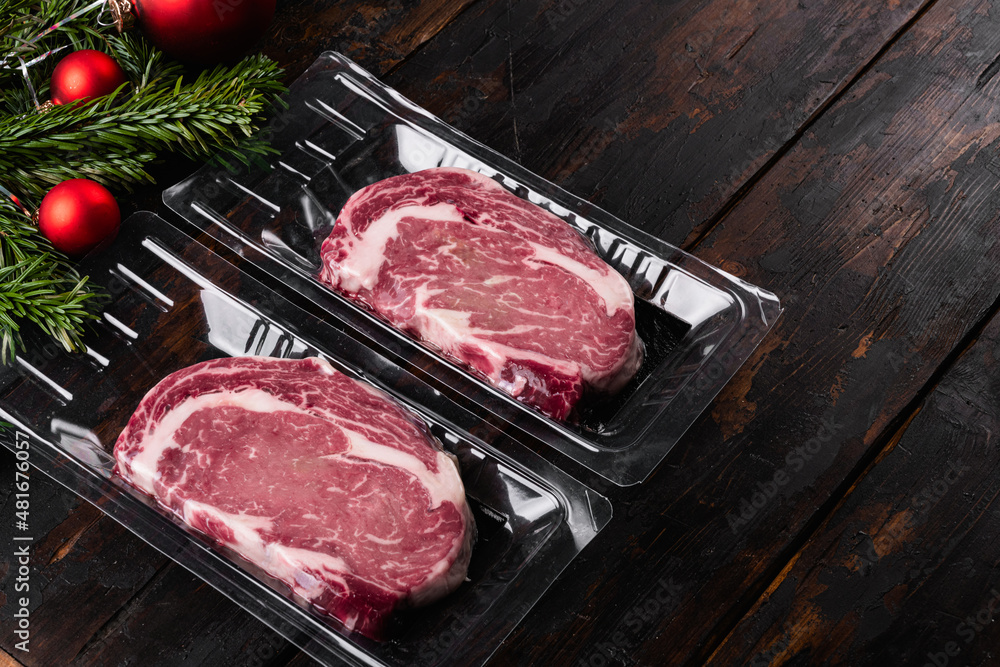 Rib eye steak pack with a Christmas tree, on old dark  wooden table background, with copy space for text