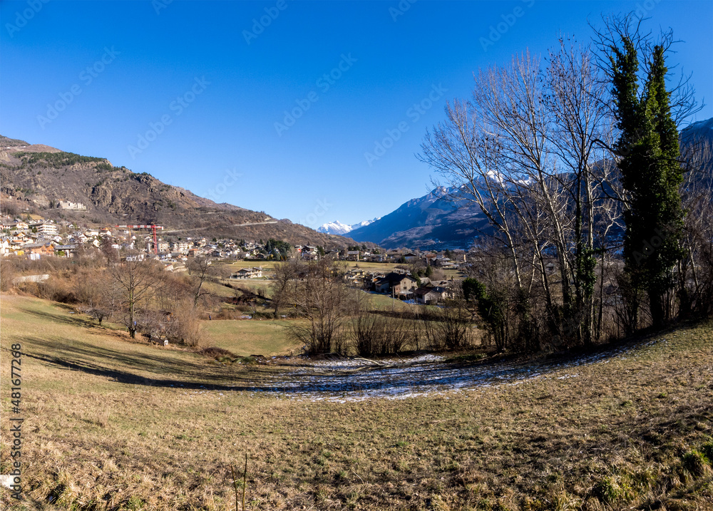 Obraz premium mountain agricultural landscape with overgrown green meadow in winter in a sunny day