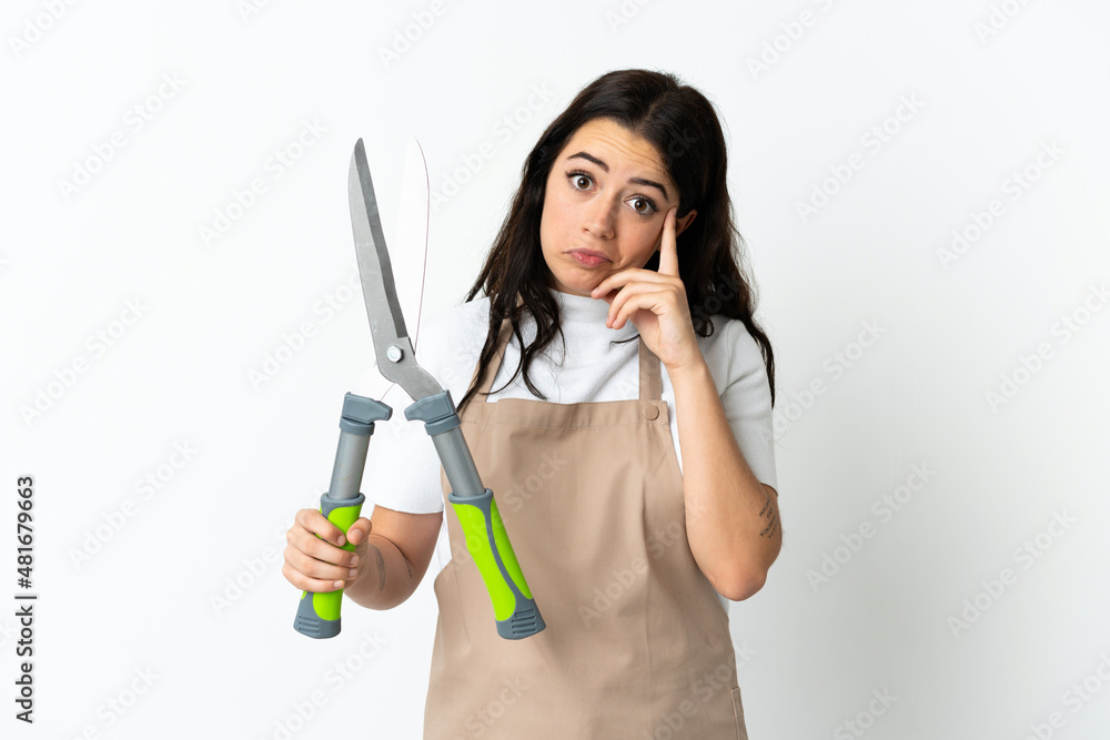 Young caucasian woman holding a plant isolated on white background thinking an idea Young caucasian woman holding a plant isolated on white background thinking an idea