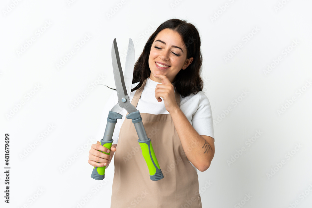 Young caucasian woman holding a plant isolated on white background looking to the side and smiling Young caucasian woman holding a plant isolated on white background looking to the side and smiling
